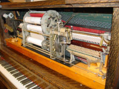 Automatic music roll changer and other parts installed above keyboard.