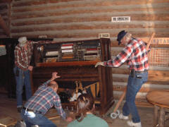 Taking the piano off the moving dolly: John Ellingsen, Larry Emmons (kneeling), Heather Hurd, Jack Frost (Chief of Maintenance).